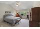 Spacious bedroom with vaulted ceiling, large window, neutral carpet, and furniture pieces at 10934 Harness Ct, Indianapolis, IN 46239