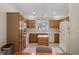 Well-lit kitchen featuring wood cabinets, white appliances, and tile flooring with an island at 10934 Harness Ct, Indianapolis, IN 46239