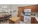 Bright kitchen featuring an island, white appliances, and wood cabinets at 10934 Harness Ct, Indianapolis, IN 46239