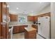 Spacious kitchen with wooden cabinetry, white appliances, and an island workstation at 10934 Harness Ct, Indianapolis, IN 46239