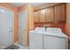 Functional laundry room featuring a washer, dryer, storage cabinets, and access doors at 10934 Harness Ct, Indianapolis, IN 46239