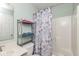 Bathroom with storage shelves, a vanity, toilet, and shower with a floral curtain at 10973 Freeman Ct, Indianapolis, IN 46234