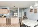 Well-lit kitchen with light cabinets, a stainless steel dishwasher, and a view into the living space at 10973 Freeman Ct, Indianapolis, IN 46234