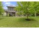 The backyard features an outdoor patio with a fire pit and comfortable seating surrounded by green grass and trees at 11393 Muirfield Trce, Fishers, IN 46037