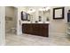 Elegant bathroom featuring double sinks, dark wood cabinetry, and a separate toilet area at 11393 Muirfield Trce, Fishers, IN 46037