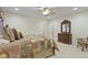 A carpeted bedroom featuring a queen-sized bed, ceiling fan, and a wooden dresser with mirror at 11393 Muirfield Trce, Fishers, IN 46037