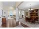 Open-concept dining room featuring dark wood floors, elegant chandelier and stylish columns at 11393 Muirfield Trce, Fishers, IN 46037