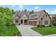 Charming brick home featuring a three-car garage, mature trees, and a meticulously maintained lawn at 11393 Muirfield Trce, Fishers, IN 46037
