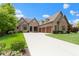 Attractive brick home with a long driveway leading to a three-car garage and mature landscaping at 11393 Muirfield Trce, Fishers, IN 46037