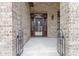 Close-up of an elegant brick home entrance featuring a decorative wood door at 11393 Muirfield Trce, Fishers, IN 46037