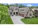 Gorgeous front exterior view highlighting the three-car garage and beautiful landscaping at 11393 Muirfield Trce, Fishers, IN 46037