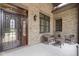 Cozy brick porch with wicker furniture, providing a welcoming outdoor seating area at 11393 Muirfield Trce, Fishers, IN 46037