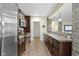 Basement kitchenette showcasing stainless steel appliances, dark cabinetry, and a breakfast bar at 11393 Muirfield Trce, Fishers, IN 46037