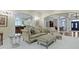 Open concept living room with elegant furniture and access to the kitchen and dining areas at 11393 Muirfield Trce, Fishers, IN 46037