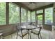 Screened-in porch with a seating area, ceiling fan, and views of the surrounding woods at 11393 Muirfield Trce, Fishers, IN 46037