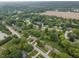 Picturesque aerial view of a quiet neighborhood surrounded by mature trees and open fields at 11409 Haverstick Rd, Carmel, IN 46033