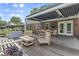 Inviting outdoor entertaining area featuring a covered deck, dining table and chairs, and cozy seating arrangement at 11409 Haverstick Rd, Carmel, IN 46033