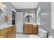 Well-lit bathroom featuring double sinks, a vanity, mirror, and a toilet at 11409 Haverstick Rd, Carmel, IN 46033