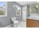Well-lit bathroom with a glass-enclosed shower, tiled floor, toilet, vanity and window with natural light at 11409 Haverstick Rd, Carmel, IN 46033
