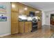 Kitchen with wooden cabinets, black countertops, and stainless steel appliances at 11409 Haverstick Rd, Carmel, IN 46033