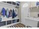 Functional mudroom with storage shelves, hooks, and a utility sink at 11409 Haverstick Rd, Carmel, IN 46033