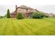Large, well-kept backyard with green grass, a screened-in porch, and manicured landscaping at 1145 Forest Commons Dr, Avon, IN 46123