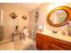 Well-lit bathroom featuring a wood vanity, round mirror, and stylish decorations at 1145 Forest Commons Dr, Avon, IN 46123