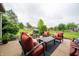 Outdoor patio with red cushioned seating, a center table, and landscaped surroundings at 1145 Forest Commons Dr, Avon, IN 46123