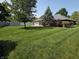 Spacious backyard with manicured lawn, trees and a patio area for entertaining at 1201 Briarwood Dr, Brownsburg, IN 46112