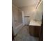 Well-lit bathroom with a vanity and shower, featuring light-colored tile at 1201 Briarwood Dr, Brownsburg, IN 46112