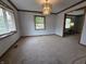 Bright living room featuring neutral carpet, updated lighting, and natural light from windows at 1201 Briarwood Dr, Brownsburg, IN 46112