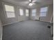 Cozy living room featuring gray walls, neutral carpet, large windows for natural light, and a ceiling fan at 1201 Briarwood Dr, Brownsburg, IN 46112
