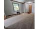 Neutral-toned living room features carpet, trim, a window, and front door at 1201 Briarwood Dr, Brownsburg, IN 46112