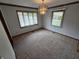 Bright living room features neutral carpet, updated lighting, and natural light from two windows at 1201 Briarwood Dr, Brownsburg, IN 46112