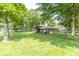 Grassy backyard showing the home's roofline and brick exterior beyond the mature trees at 12014 Briar Way Center Dr, Indianapolis, IN 46126