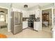 Modern kitchen with stainless steel appliances, white cabinets, and a view into the dining area shows practical functionality at 12014 Briar Way Center Dr, Indianapolis, IN 46126