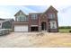 New two-story brick home featuring an attached two-car garage and unfinished landscaping at 12338 French Cattle Way, Noblesville, IN 46060