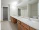 Bathroom with double sinks, wood cabinets, and a large mirror at 12382 Cool Winds Way, Fishers, IN 46037
