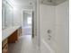 Bright bathroom showcasing a shower-tub combo and wooden cabinets at 12382 Cool Winds Way, Fishers, IN 46037