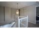 Hallway landing with white wooden railings and a decorative light fixture at 12382 Cool Winds Way, Fishers, IN 46037