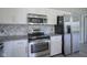 Well-equipped kitchen featuring stainless steel appliances, white cabinetry, and stone countertops at 12382 Cool Winds Way, Fishers, IN 46037