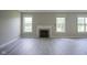 Living room featuring a fireplace, large windows, and hardwood flooring at 12382 Cool Winds Way, Fishers, IN 46037