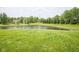 Beautiful pond surrounded by lush greenery and mature trees at 12382 Cool Winds Way, Fishers, IN 46037