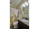 Bright bathroom featuring granite countertop, decorative shower curtain, and updated fixtures at 13429 Boxelder Ct, Carmel, IN 46074