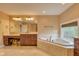 Well lit bathroom with a large tub, vanity, and marble tiled floors at 13429 Boxelder Ct, Carmel, IN 46074