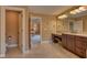Warm toned bathroom with vanity, tiled floors, and access to the main bedroom at 13429 Boxelder Ct, Carmel, IN 46074