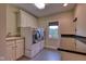 Bright laundry room with a front load washer and dryer, utility sink, sleek countertops, and ample cabinet storage at 13429 Boxelder Ct, Carmel, IN 46074