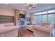 Cozy living room featuring a stone fireplace, hardwood floors, and large windows at 13429 Boxelder Ct, Carmel, IN 46074