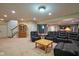 A spacious carpeted living room with reclining leather chairs and table adjacent to stairs and kitchen at 13429 Boxelder Ct, Carmel, IN 46074