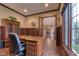 Office featuring wood flooring, wood paneling, and a large window at 13429 Boxelder Ct, Carmel, IN 46074
